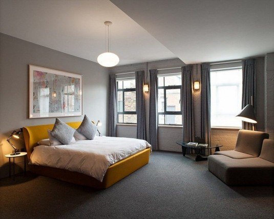 Cozy-grey-bedroom-with-dramatic-lighting-also-cheerful-yellow-platform-bed-also-neutral-color-pallet-and-large-glazed-windows-1024x819