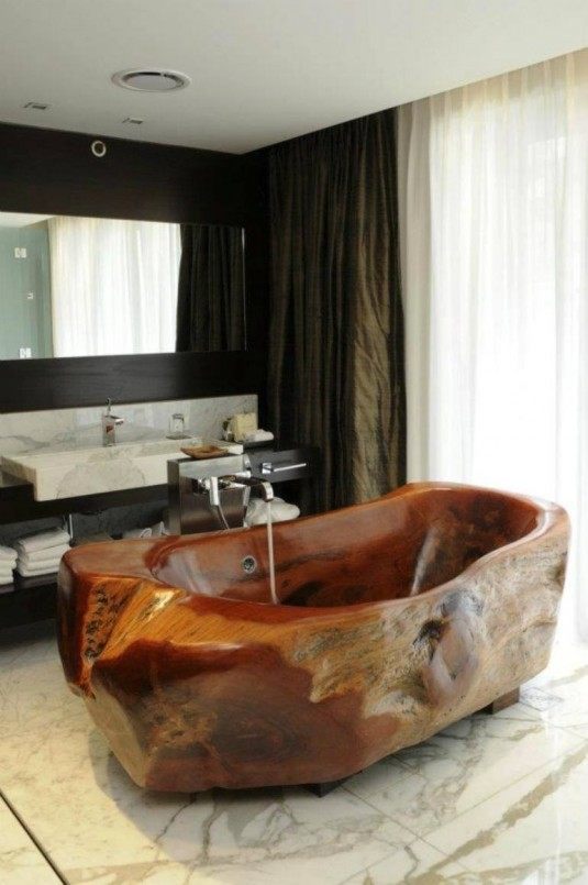 Appealing-modern-bathroom-featuring-interior-design-with-wooden-bathtub-on-marble-floor-chrome-faucet-in-front-of-vanity-equipped-with-sink-and-towel-storage