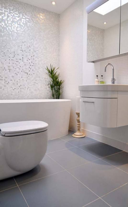 lovely-half-bathroom-design-with-elliptical-fix-bathtub-beside-stylish-white-closet-and-floating-sink-cabinet-vanity-added-with-curved-steel-faucet