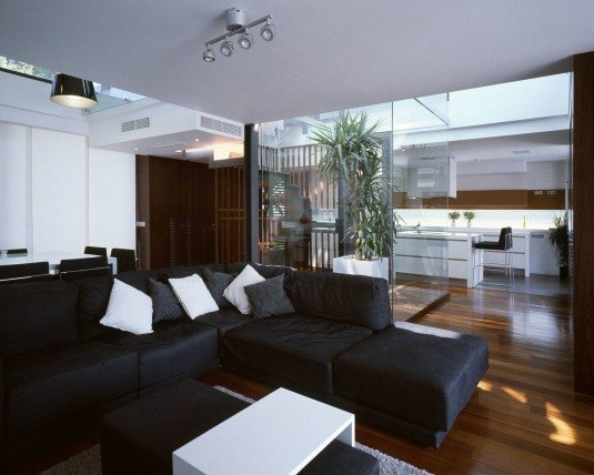 modern-living-room-interior-design-with-black-sectional-sofa-and-white-sleek-coffee-table-and-dark-hardwood-floor-decor-ideas