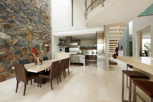 Modern interior in big house with dining room and stone wall