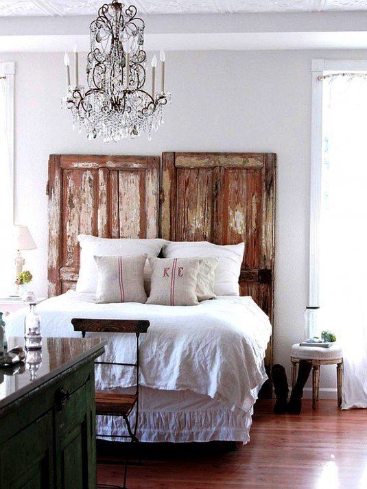 interior-furniture-bedroom-black-iron-mixed-crystal-branched-uplight-chandelier-over-rustic-queen-bed-frame-having-distressed-door-headboard-chandeliers-in-bedrooms